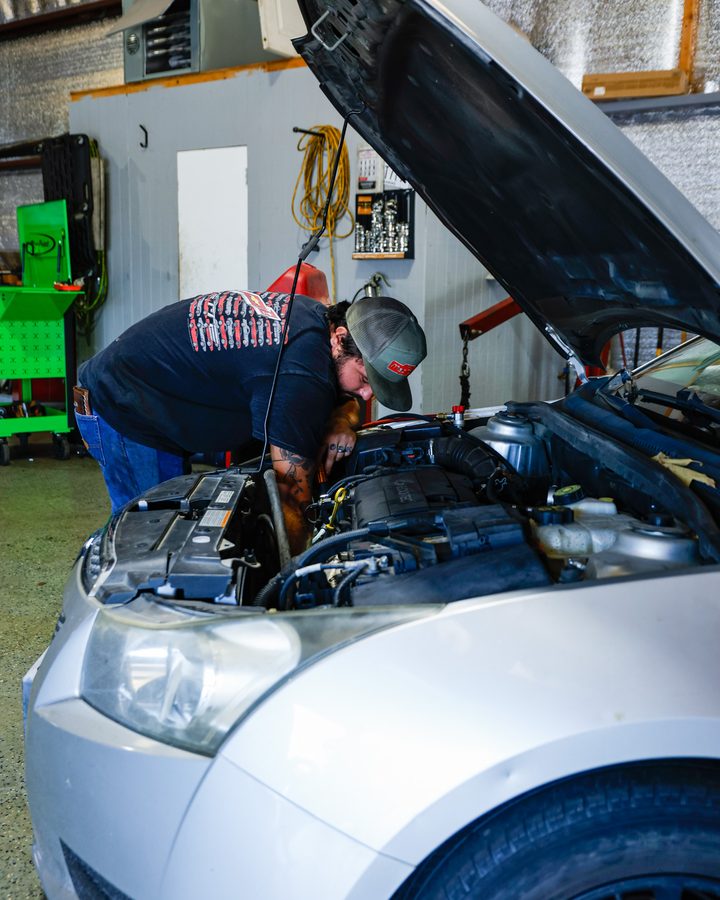 Two technicians tracing an electrical fault under the hood in North Little Rock, Arkansas