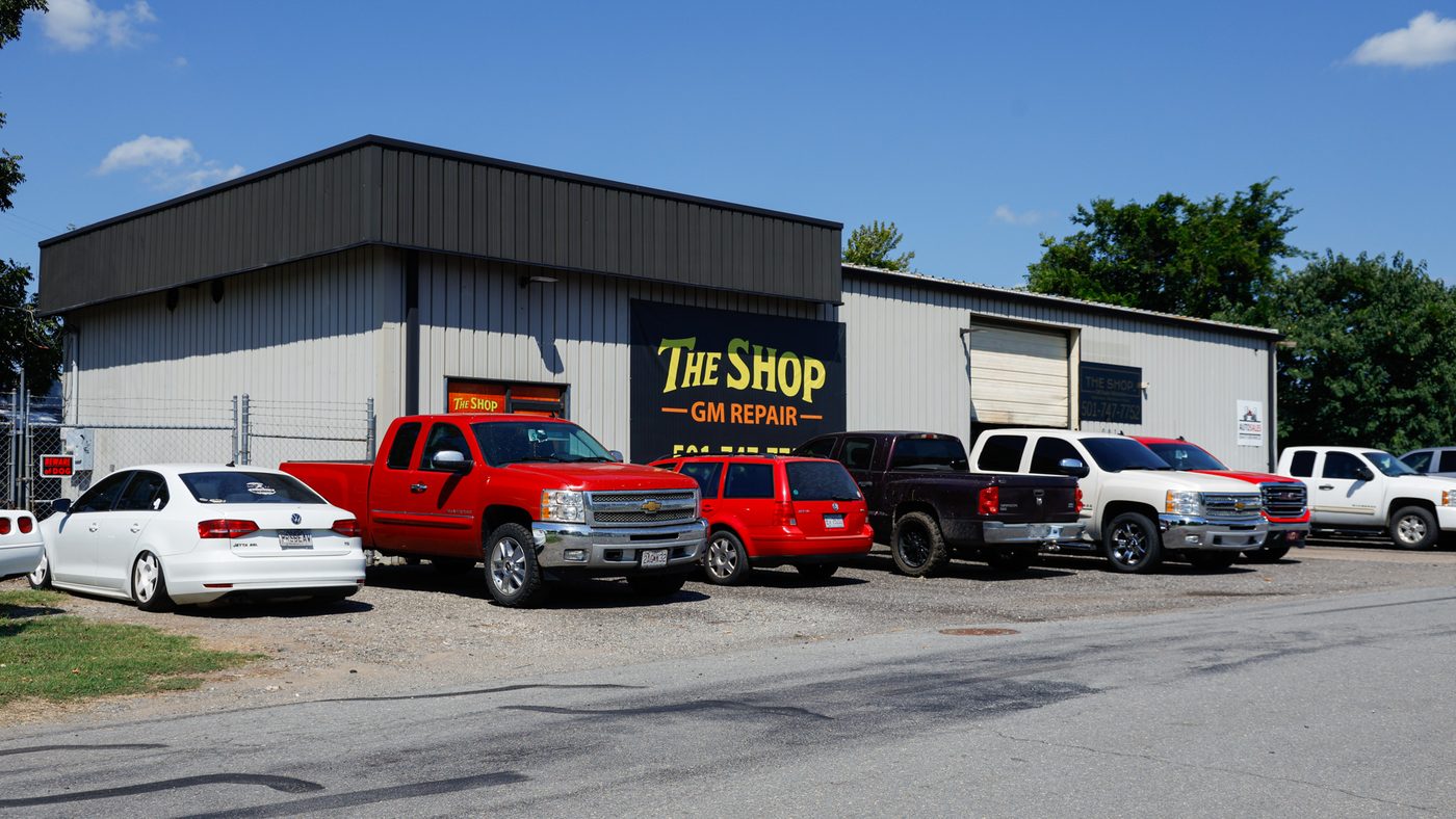 The Shop, GM Repair building on North Olive Street in North Little Rock, Arkansas, with customer trucks parked out front