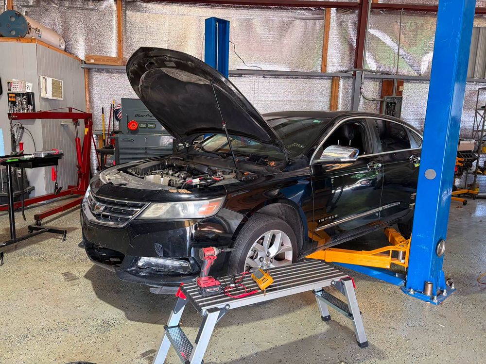Black Chevy Impala on the lift for alternator replacement in North Little Rock, Arkansas