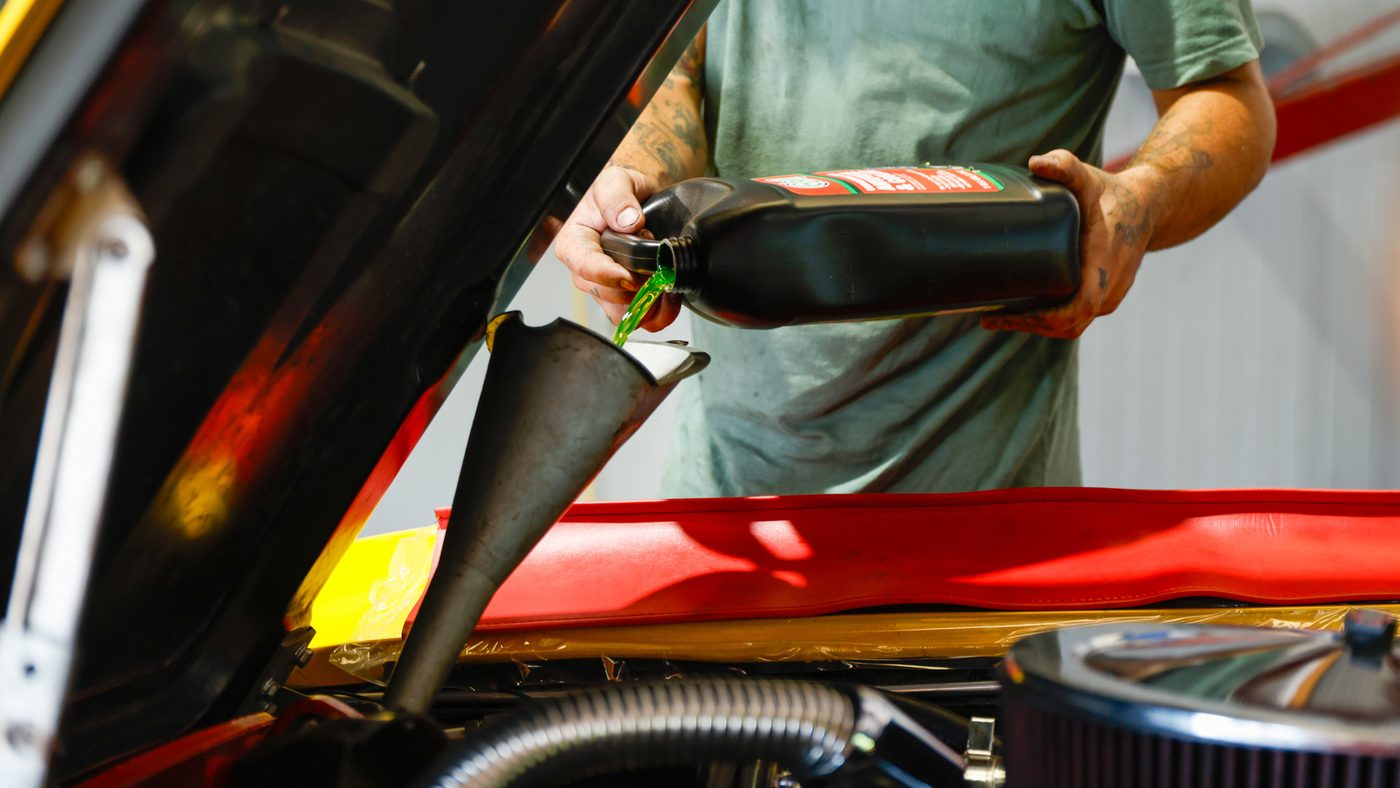 Technician topping up coolant during a fluid service in North Little Rock, Arkansas