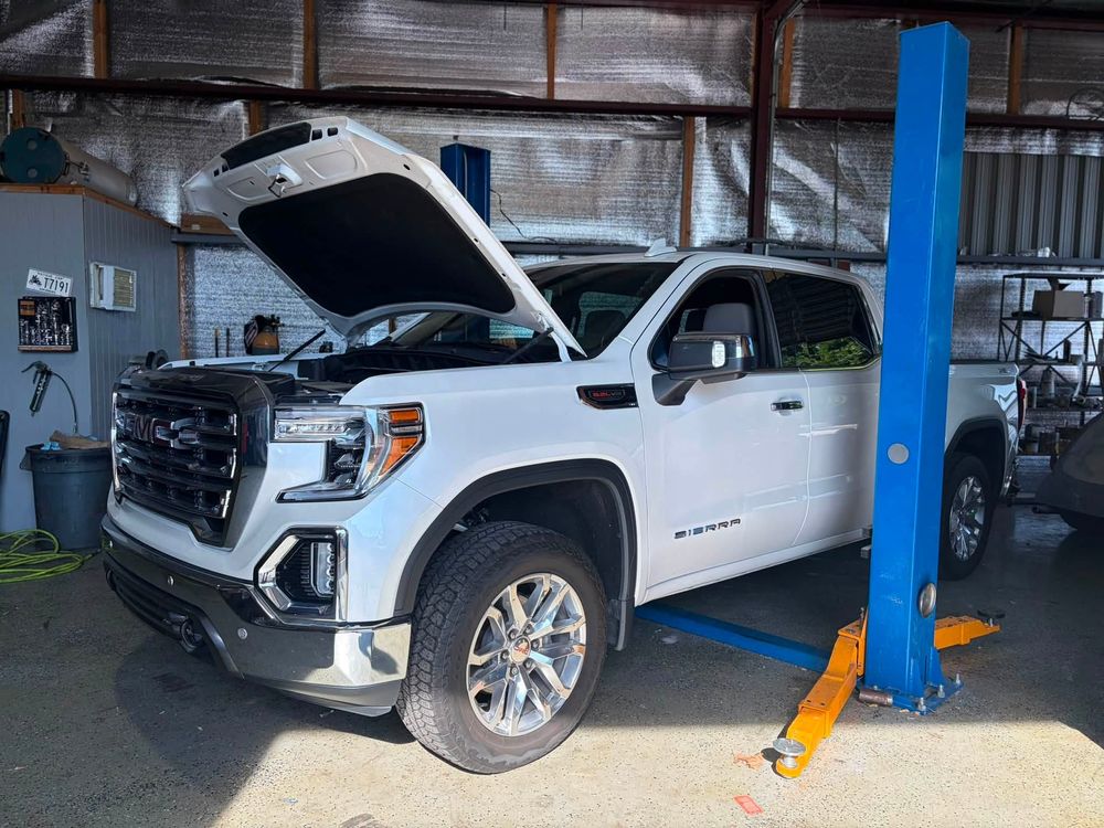 White GMC Sierra on the lift for tire and TPMS sensor service in North Little Rock, Arkansas