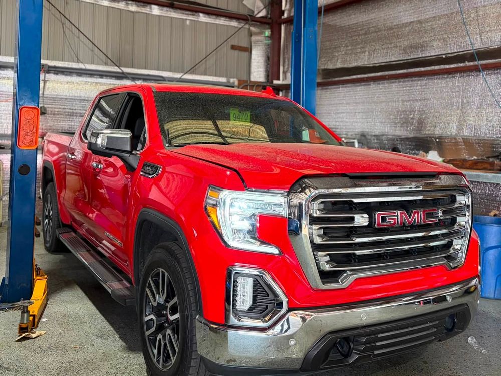 Red GMC Sierra on the lift for transmission shudder diagnosis in North Little Rock, Arkansas